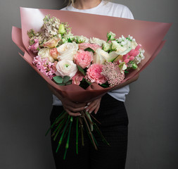 a large beautiful spreading bouquet of flowers in the hands of a girl, the work of a florist master, fresh flowers