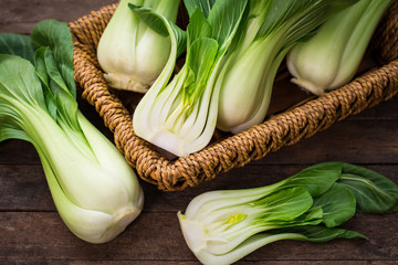 Pak choi in the basket on the wooden table - obrazy, fototapety, plakaty