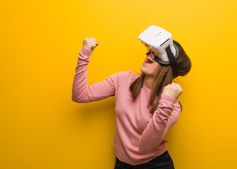 Young cute woman wearing a virtual reality googles surprised and shocked