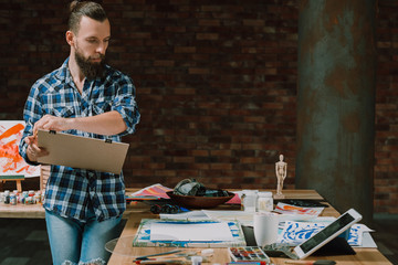 Studying fine art. Self education. Creative workplace. Young lefthanded man watching online...