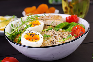 Fresh salad. Breakfast bowl with oatmeal, chicken fillet, tomato, lettuce, microgreens and boiled egg. Healthy food. Vegetarian buddha bowl.