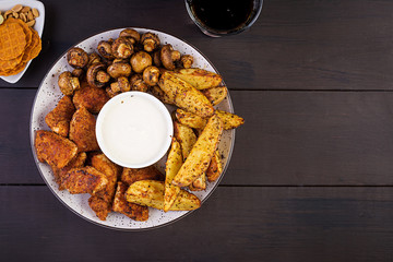 Fast food chicken nuggets with ketchup, french fries, baked mushrooms and cola. Top view
