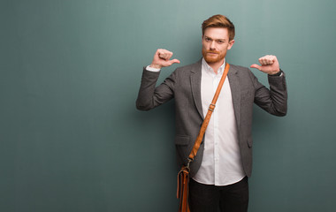 Young redhead business man pointing fingers, example to follow