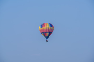 Hot air balloon over cosmos flowers with blue sky