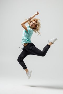 Hip hop dancer moving and jumping in studio
