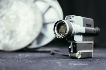 Movie production: vintage old movie camera on the floor, production studio in the background