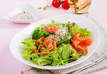 Diet menu. Healthy salad of fresh vegetables - tomatoes, avocado, arugula, seeds and salmon on a bowl. Vegan food.
