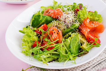 Diet menu. Healthy salad of fresh vegetables - tomatoes, avocado, arugula, seeds and salmon on a bowl. Vegan food.