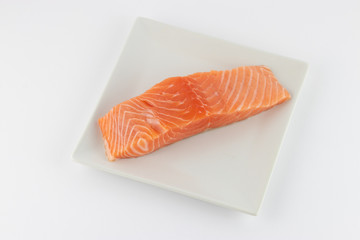 Salmone crudo su piatto e sfondo bianco