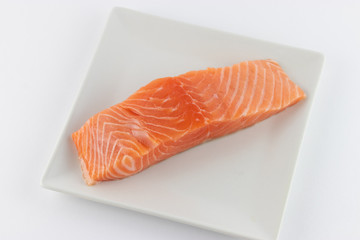 Salmone crudo su piatto e sfondo bianco