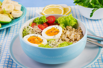 Fresh salad. Breakfast bowl with oatmeal, tomatoes, lettuce, microgreens and boiled egg. Healthy food. Vegetarian buddha bowl.