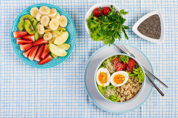 Fresh salad. Breakfast bowl with oatmeal, tomatoes, lettuce, microgreens and boiled egg. Healthy food. Vegetarian buddha bowl. Top view, flat lay