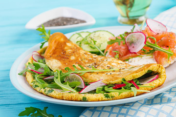 Breakfast. Omelette with radish, green arugula and sandwich with salmon on white plate.  Frittata - italian omelet.