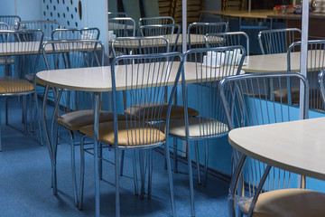 Empty tables in a closed cafe with mirror wall