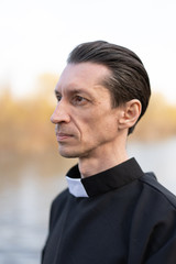 Portrait of handsome catholic priest or pastor with collar