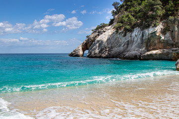 türkiser blauer geheimer Strand umgeben von Felsen, glasklares Wasser