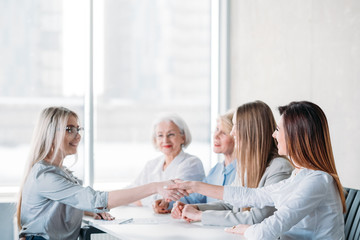 Job interview. Successful business career. Human resources. Female recruiters greeting young ambitious applicant, shaking hands.