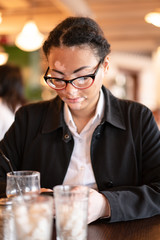A beautiful young girl of African ethnicity with vitiligo sitting in a restaurant