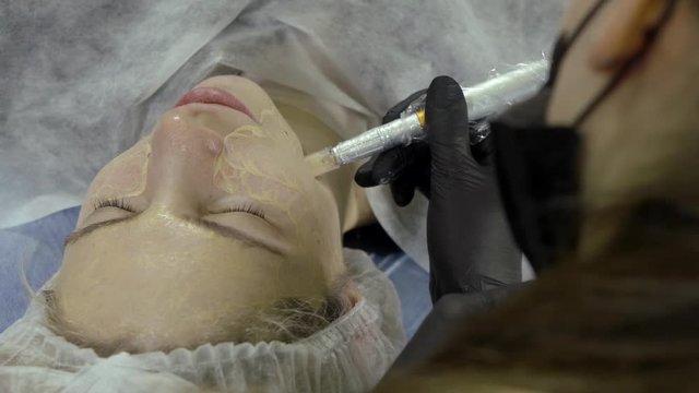 the girl lies in the beauty salon and she is doing on the face of micro-injection of Foundation. This procedure is called "bb glow treatment".