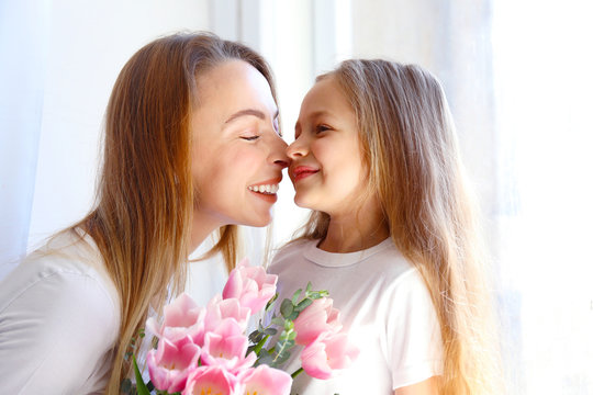 Cute little five year old girl giving her mom a present for mothers day. Adorable scene with daughter surprizing her mum. Close up, background, portrait.