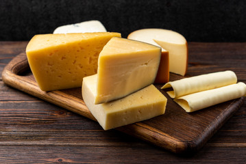 Cheese on dark wooden background.