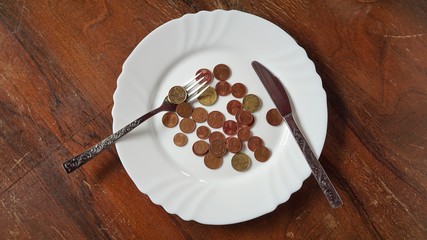 Euro Cents Münzen auf einem Teller mit Besteck
