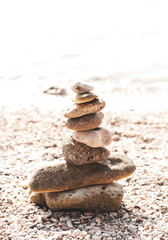 Fototapeta na wymiar Stones are lined with pyramid on beach