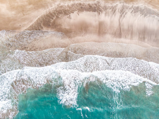 Aerial view of sandy beach with tourists swimming in beautiful clear sea water