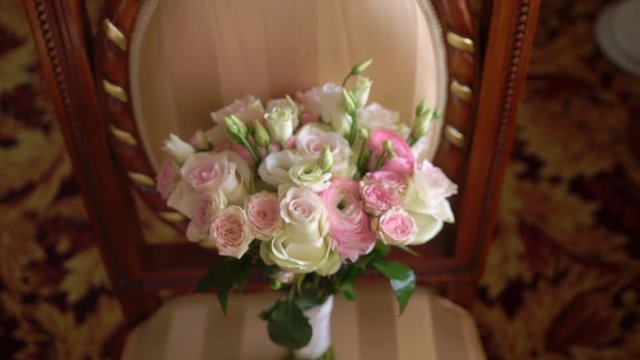 Bridal bouquet of white and pink roses on chair