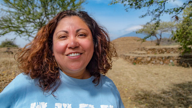 Beautiful sexy Mexican woman smiling in front of a archaeological  site with a circular Aztec pyramid in Guachimontones in Teuchitlan in the state of Jalisco Mexico on a beautiful sunny day