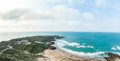 Aerial view of sandy beach with tourists swimming in beautiful clear sea water