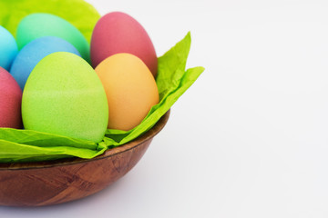 Colorful easter eggs in wooden basket on white background with copy space - 261333523