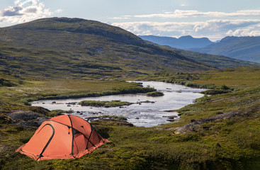 oranges Zelt im Fjell, einsame verlassene Landschaft, camping in den Bergen an einem See