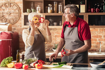 Positive senior couple having fun on kitchen
