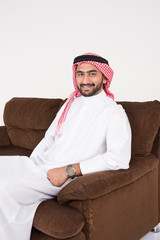 Arab man sitting on sofa chair at home