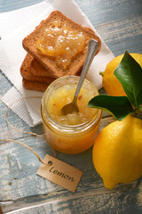 lemon jam in the glass jar with fruit around