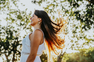 Naklejka premium young happy girl with her hair blowing in the wind at the park