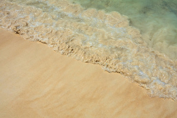 Soft wave of blue ocean on sandy beach. Background.