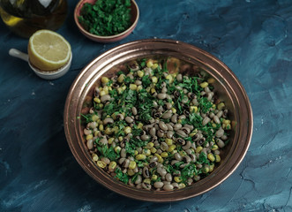 Appetizers dry cowpea salad with corns and parsley on blue background
