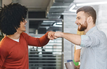 Friendly men coworkers having agreement, givint fist bump