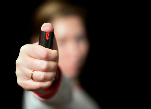 girl with pepper spray on a black background
