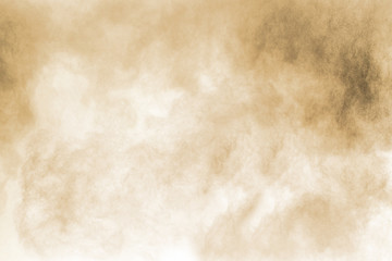 Freeze motion of brown dust explosion. Stopping the movement of brown powder. Explosive brown powder on white background.