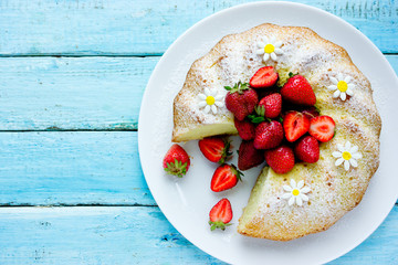 Classic vanilla bundt cake with strawberries and powdered sugar top view