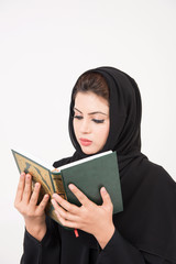 Arab muslim woman reading the holy Quran and praying