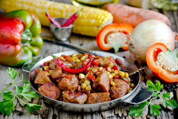 Mexican meat - pork stewed with vegetables corn, pepper, onion, carrot in gravy
