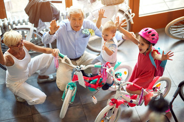 happy senior family with grandchildren buying new bicycle.