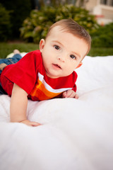 Happy Baby Boy Lying on Blanket Outside - Color Portrait