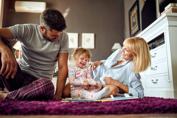 Cute child showing puzzle to parents