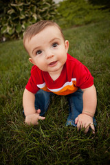 Happy Baby Boy Sitting in Grass Outside - Color Portrait