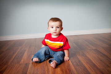 Happy Baby Boy Sitting on Wood Floor in Home - Color Portrait